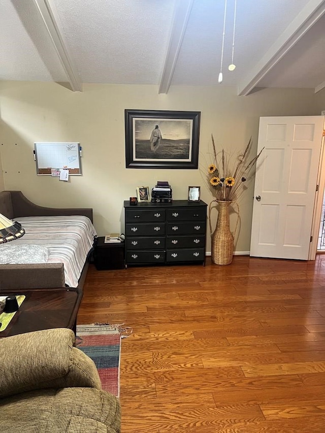 bedroom featuring beamed ceiling and hardwood / wood-style flooring