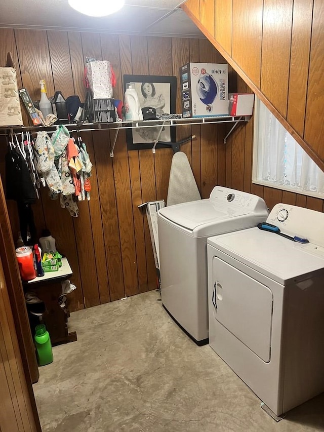 laundry room with wooden walls and independent washer and dryer