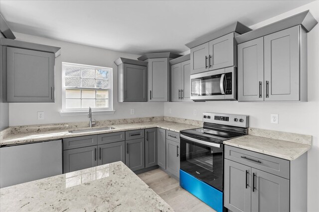 519 Abigail St, Dalton, GA 30721 - kitchen featuring appliances with stainless steel finishes, a sink, gray cabinets, and light wood-style flooring
