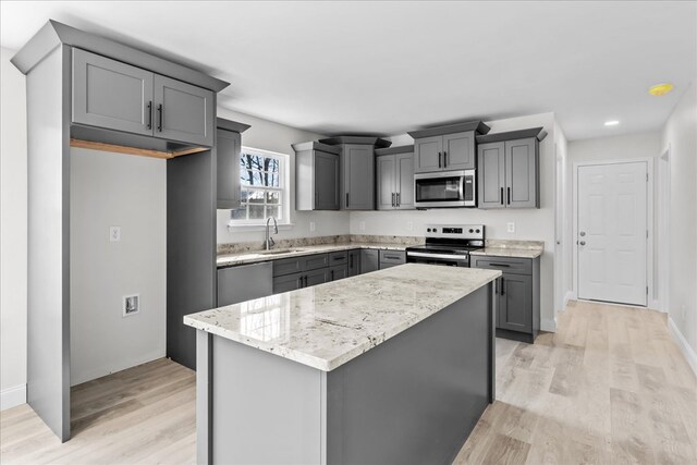 519 Abigail St, Dalton, GA 30721 - kitchen with stainless steel appliances, gray cabinets, light wood finished floors, a sink, and a kitchen island