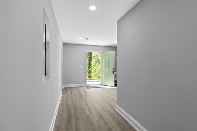 corridor with wood finished floors, baseboards, and recessed lighting