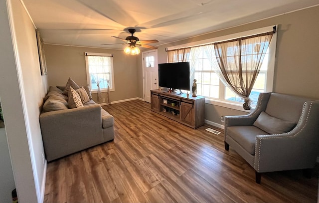 living room with visible vents, baseboards, wood finished floors, and a ceiling fan