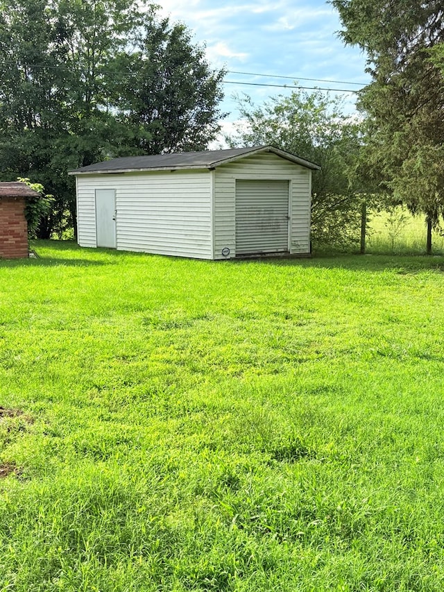 view of grassy yard featuring an outbuilding and a storage unit