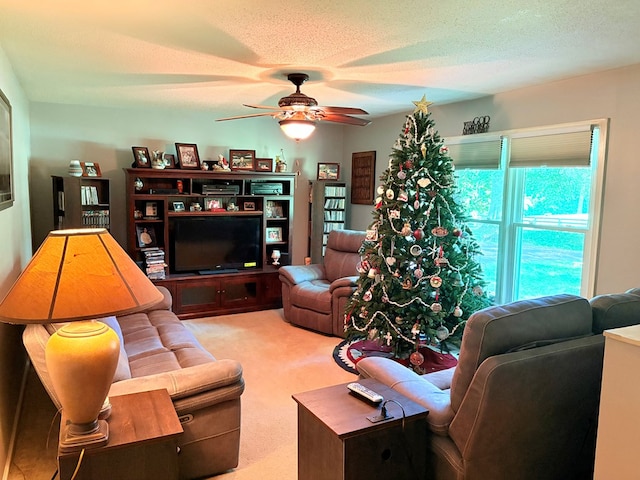 living room featuring ceiling fan, light carpet, and a textured ceiling