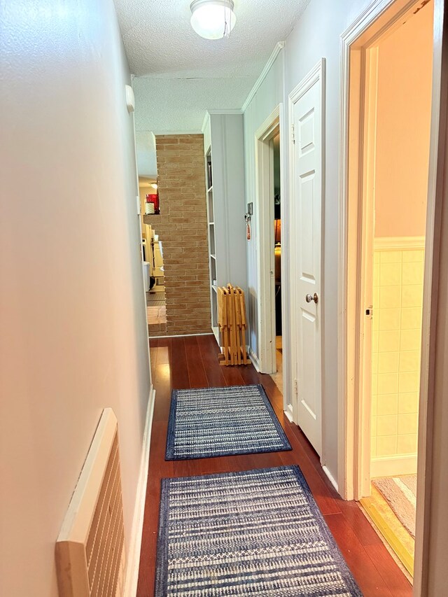 corridor featuring wood finished floors and a textured ceiling