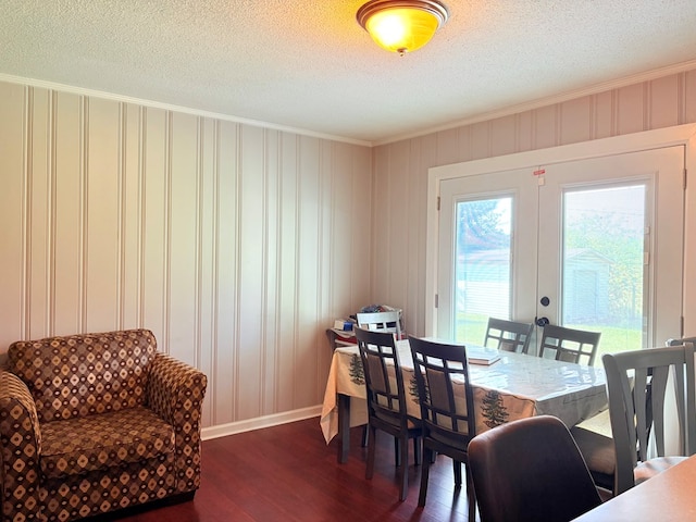 dining area featuring dark wood-type flooring, crown molding, a textured ceiling, french doors, and baseboards