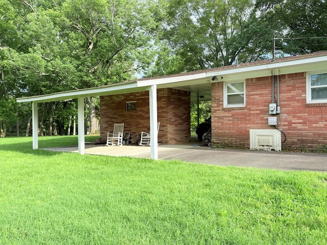 back of house featuring a yard and brick siding