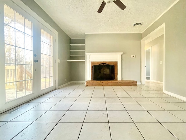 unfurnished living room featuring light tile patterned floors, a textured ceiling, and a fireplace