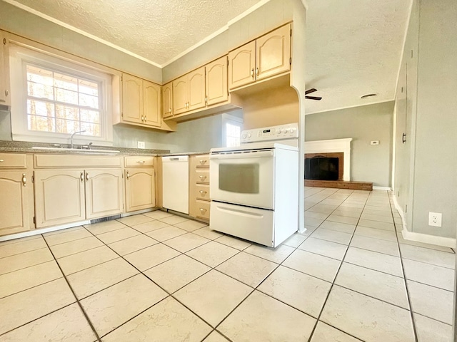 kitchen featuring sink, white appliances, light tile patterned floors, a textured ceiling, and light brown cabinets