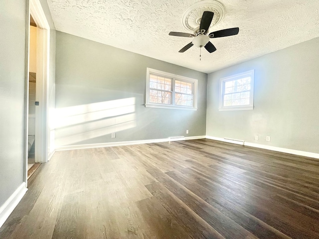 empty room with ceiling fan, hardwood / wood-style flooring, and a textured ceiling