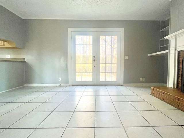 unfurnished living room with french doors, light tile patterned flooring, and a textured ceiling