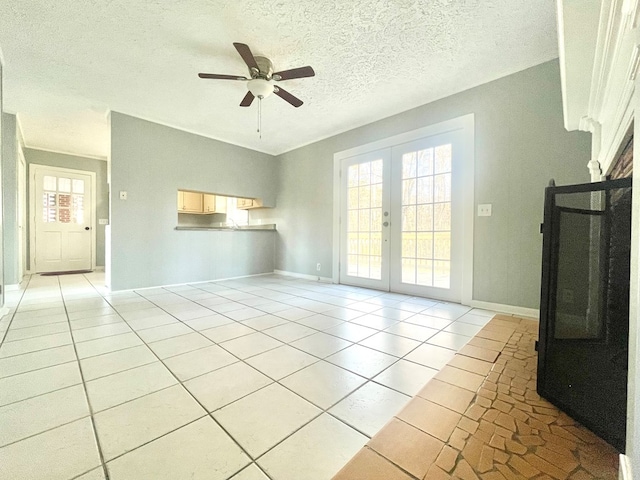 unfurnished living room featuring light tile patterned flooring, ceiling fan, a textured ceiling, and french doors