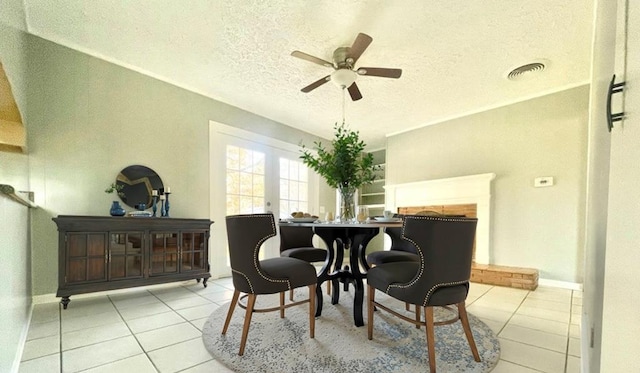 tiled dining room with ceiling fan and a textured ceiling