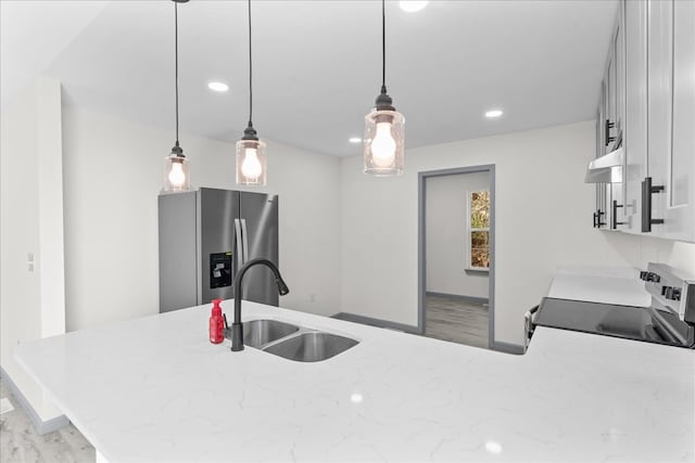 kitchen with sink, pendant lighting, stainless steel fridge, kitchen peninsula, and electric stove