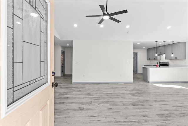 unfurnished living room featuring ceiling fan, lofted ceiling, and light hardwood / wood-style floors