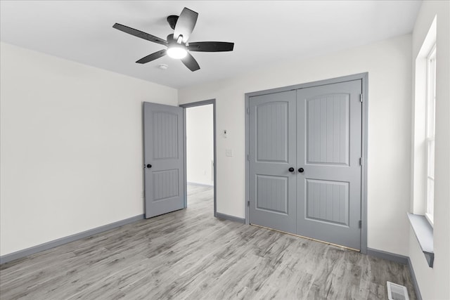 unfurnished bedroom with ceiling fan, light hardwood / wood-style floors, and a closet