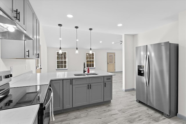 kitchen with appliances with stainless steel finishes, decorative light fixtures, sink, gray cabinetry, and kitchen peninsula