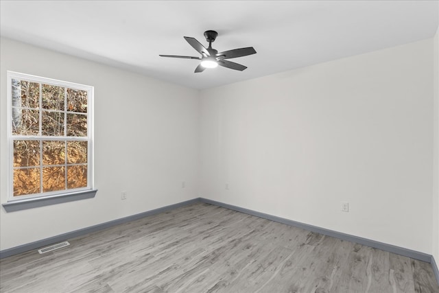 spare room with ceiling fan, plenty of natural light, and light hardwood / wood-style floors