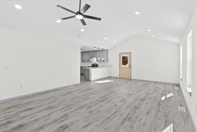 unfurnished living room with vaulted ceiling, ceiling fan, and light hardwood / wood-style floors