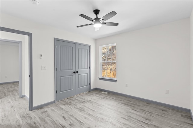 unfurnished bedroom with a closet, ceiling fan, and light wood-type flooring