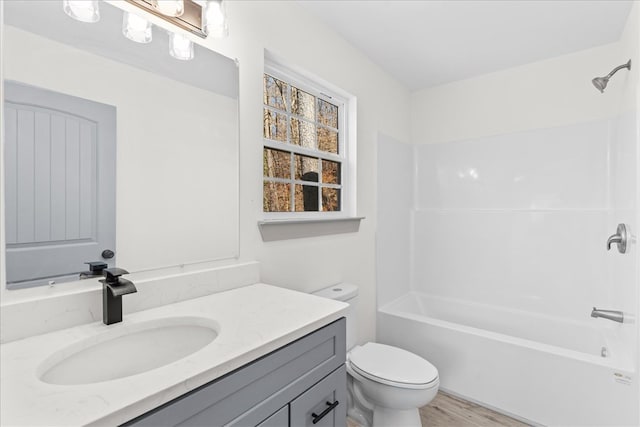 full bathroom featuring vanity, hardwood / wood-style floors,  shower combination, and toilet