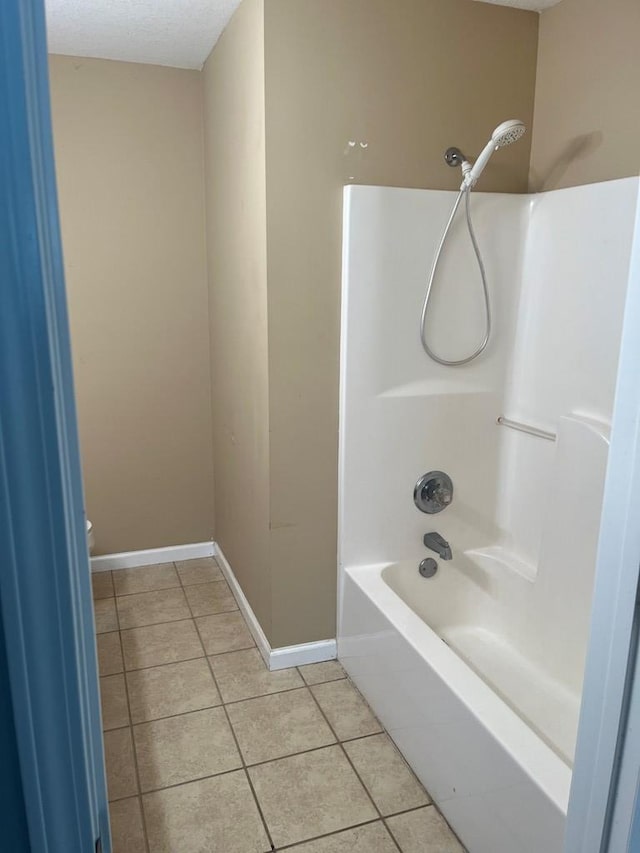 bathroom featuring tile patterned flooring, shower / washtub combination, and toilet