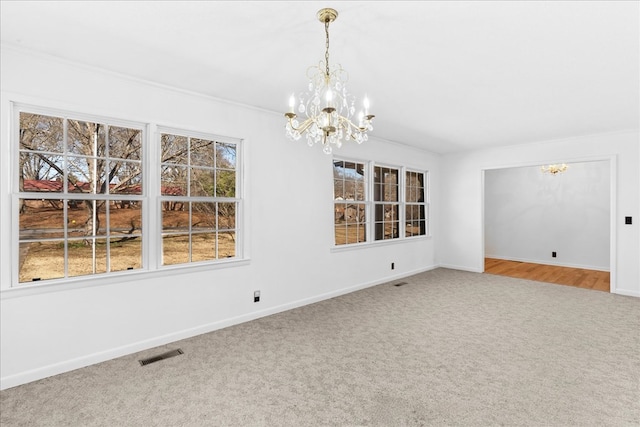 unfurnished dining area with crown molding, carpet flooring, and an inviting chandelier