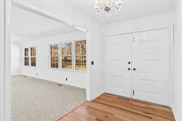 entrance foyer featuring a notable chandelier, crown molding, and hardwood / wood-style flooring