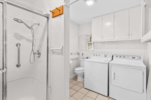 laundry area with light tile patterned flooring and washer and clothes dryer