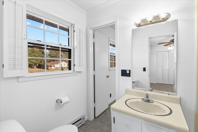 bathroom featuring ceiling fan, a baseboard heating unit, vanity, ornamental molding, and toilet