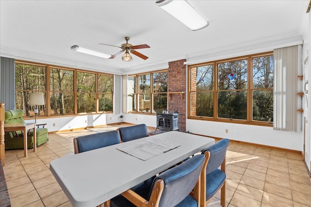 sunroom / solarium with a wood stove and ceiling fan