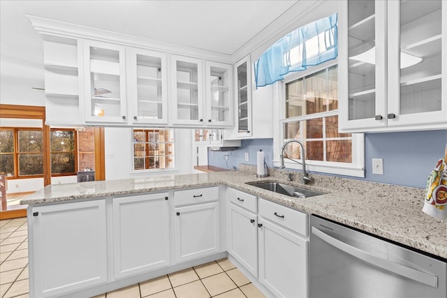 kitchen with light tile patterned floors, sink, dishwasher, white cabinets, and kitchen peninsula