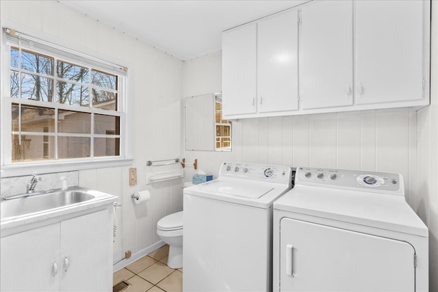 laundry room featuring washer and clothes dryer, sink, and light tile patterned floors