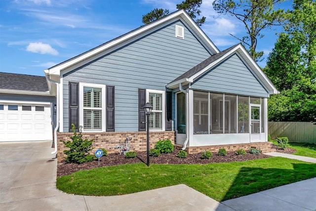 view of front of house with a garage, a sunroom, and a front yard