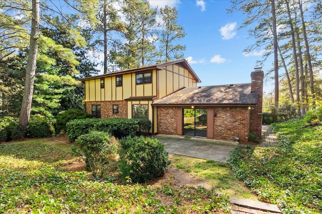 608 Brookview Ln, Dalton, GA 30720 - rear view of house featuring board and batten siding, brick siding, a chimney, and a patio area