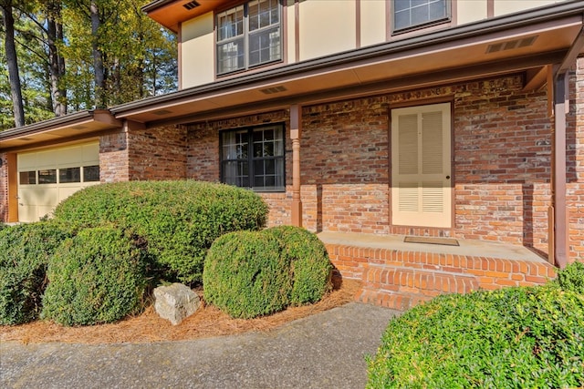 608 Brookview Ln, Dalton, GA 30720 - view of exterior entry featuring brick siding, a garage, and covered porch