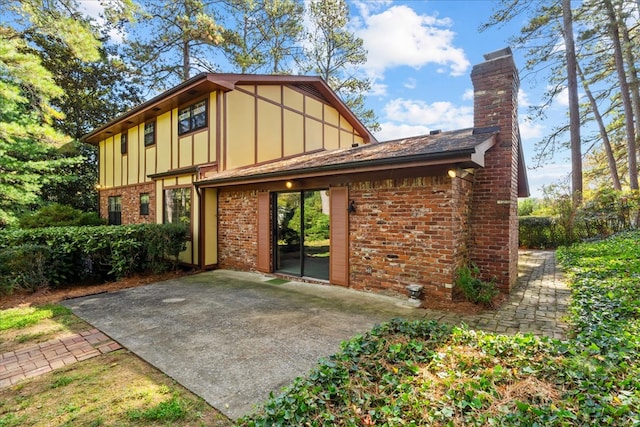 608 Brookview Ln, Dalton, GA 30720 - back of property featuring board and batten siding, brick siding, a patio, and a chimney