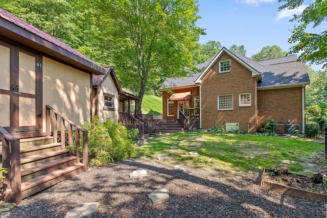 2001 Eagle Point Dr, Dalton, GA 30720 - back of property featuring brick siding, a vegetable garden, roof with shingles, and a deck