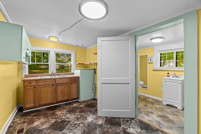 1098 Mount Vernon Rd, Tunnel Hill, GA 30755 - kitchen with a sink, dark stone finish floors, brown cabinetry, crown molding, and baseboards