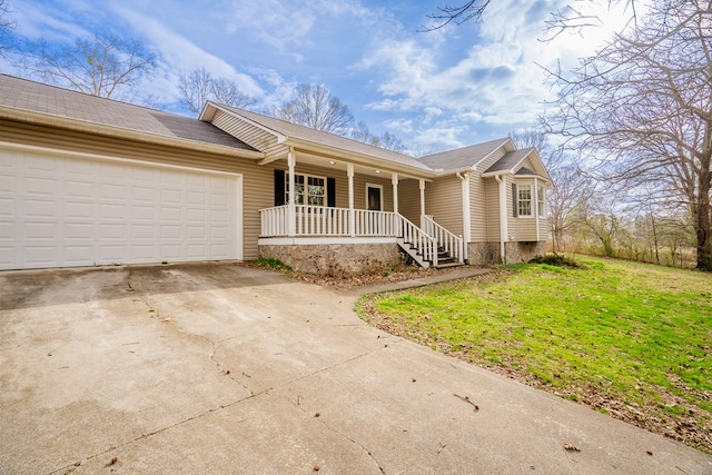 ranch-style home with a porch, an attached garage, a front yard, and driveway