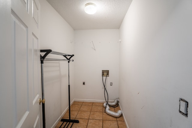 clothes washing area featuring hookup for a washing machine, light tile patterned floors, hookup for an electric dryer, laundry area, and a textured ceiling