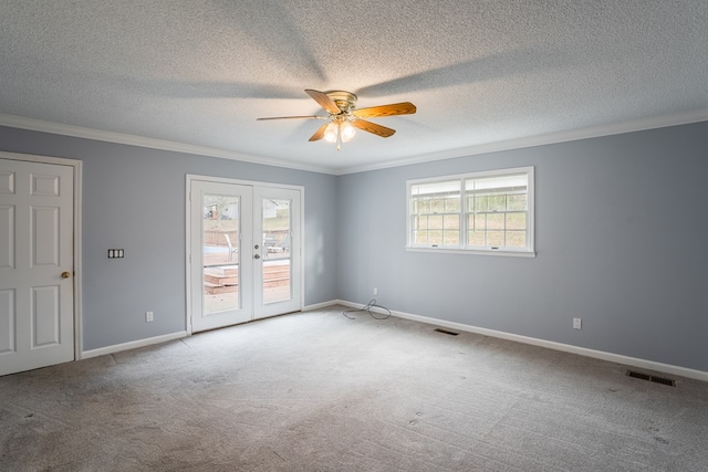 unfurnished room featuring carpet, plenty of natural light, a ceiling fan, and visible vents