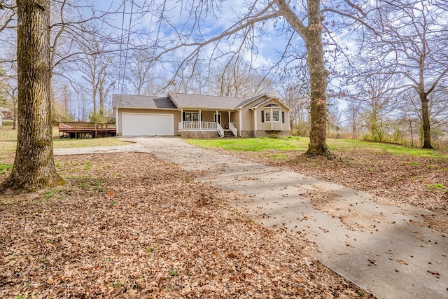view of front of property with a porch, concrete driveway, and an attached garage