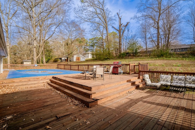wooden terrace featuring a covered pool, grilling area, an outdoor living space, and fence