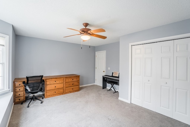 office featuring baseboards, carpet flooring, a textured ceiling, and a ceiling fan