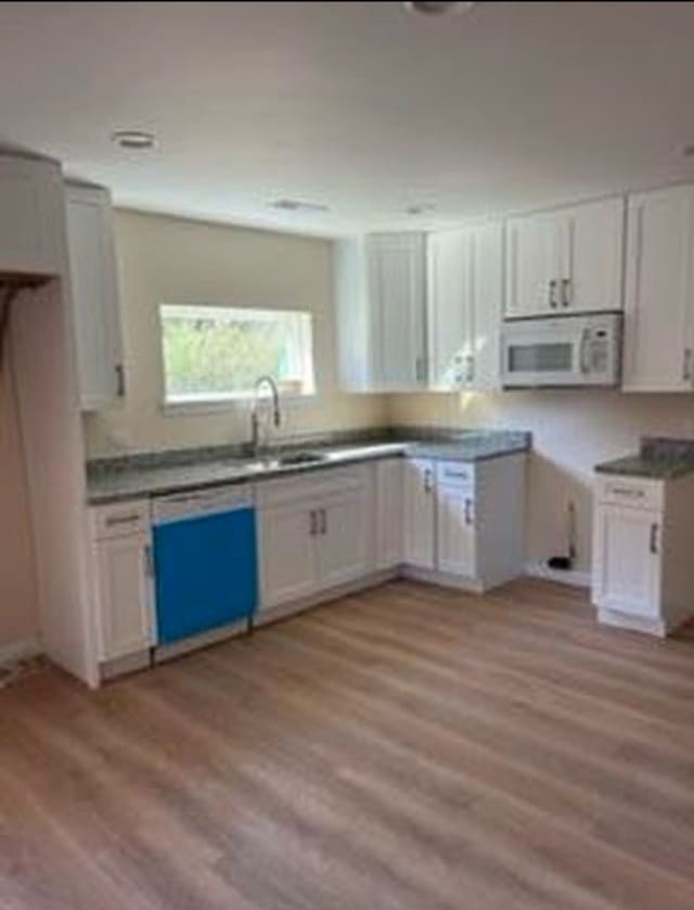 kitchen featuring white cabinetry, sink, light hardwood / wood-style flooring, and dishwasher