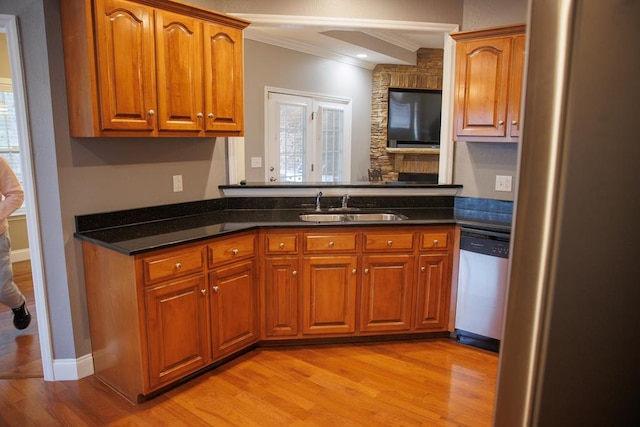 kitchen featuring crown molding, appliances with stainless steel finishes, sink, and light hardwood / wood-style flooring