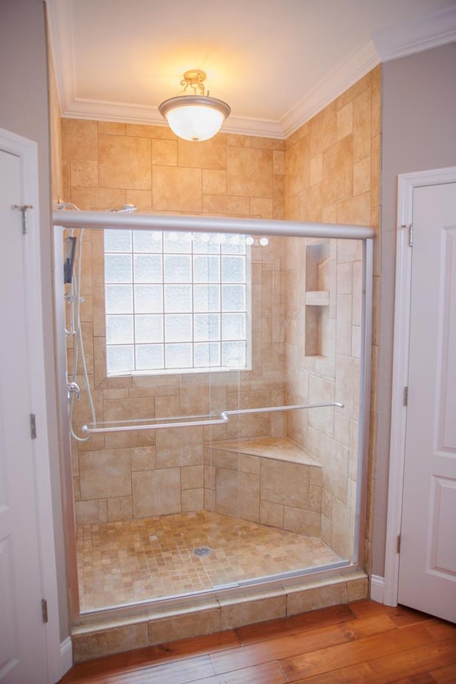 bathroom featuring hardwood / wood-style floors, ornamental molding, and walk in shower