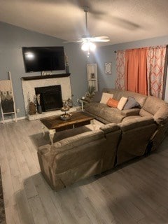 living room with vaulted ceiling, hardwood / wood-style floors, and ceiling fan