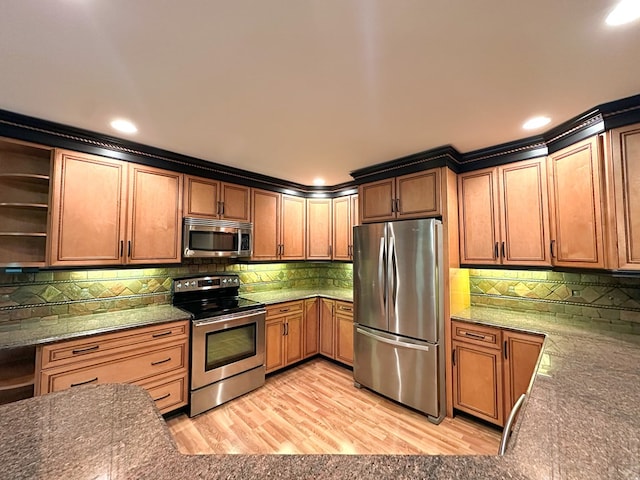 kitchen featuring appliances with stainless steel finishes, light hardwood / wood-style floors, and decorative backsplash